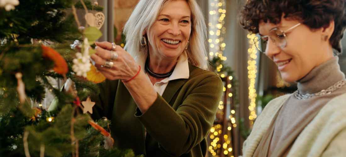 mother and daughter decorating a christmas tree